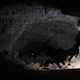 The huge lava tube in Umm Jirsan, with high ceilings, silhouetting one of the team members.